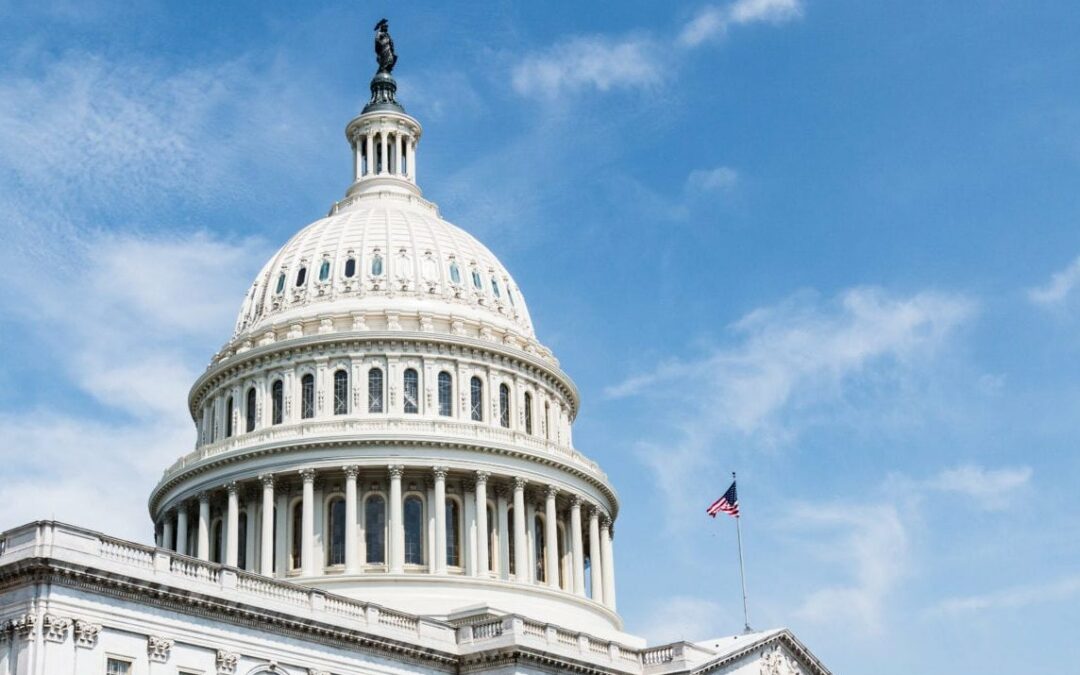 Picture of US Capitol Dome against a blue sky with American flag flying